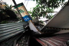 Khoảng 8 giờ tại khu nhà trong ngõ 72 Thợ Nhuộm (Hoàn Kiếm, Hà Nội), một khối bêtông kèm vật liệu xây dựng đã bất ngờ đổ ập lên mái một dãy 3 ngôi nhà trong ngõ. (Ảnh: Võ Phương/Vietnam+)