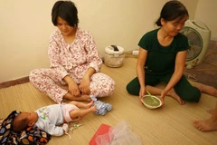 Chị Tuyết cùng bé 10 ngày tuổi may mắn thoát ra từ đám cháy tầng cao chung cư HH4a Linh Đàm. (Ảnh: Minh Sơn/Vietnam+)