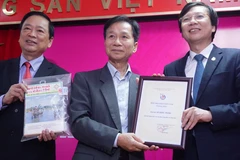 Nhà báo Lê Quốc Trung - Nguyên Tổng giám đốc Thông tấn xã Việt Nam (giữa) trao tặng hiện vật tới Bảo tàng Báo chí Việt Nam. (Ảnh: Võ Phương/Vietnam+)