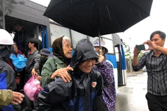 Chính quyền địa phương và doanh nghiệp hỗ trợ người dân Quảng Ngãi sơ tán tới nơi an toàn tránh bão số 4. (Ảnh: Đinh Hương/TTXVN)