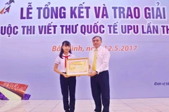 Thứ trưởng Bộ Thông tin và Truyền thông Nguyễn Minh Hồng trao giải nhất cuộc thi viết thư quốc tế UPU lần thứ 46 cho tác giả Nguyễn Đỗ Huyền Vi, học sinh lớp 8/9 Trường THCS Tây Sơn, Đà Nẵng. (Ảnh: Minh Quyết/TTXVN)