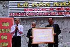 Đại diện Câu lạc bộ truyền thống kháng chiến khối Cơ quan Dân Chính đảng Trung ương Cục miền Nam đón nhận Bằng xếp hạng di tích cấp quốc gia. (Ảnh: Lê Đức Hoảnh/TTXVN)
