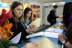 Khách tham quan tìm hiểu về các sản phẩm du lịch và bản đồ Việt Nam. (Ảnh: Nguyễn Thanh Bình/Vietnam+)