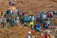 Lực lượng cứu hộ và người dân tìm kiếm người mất tích sau trận lở đất ở ngoại ô Freetown ngày 14/8. (Ảnh: EPA/TTXVN)