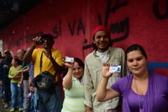 Người dân Venezuela xếp hàng chờ bỏ phiếu tại điểm bầu cử ở Caracas ngày 30/7. (Ảnh: AFP/TTXVN)