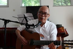 Tiến sỹ Đào Minh Quang - sáng lập Quỹ Đào Minh Quang, chuẩn bị một tiết mục biểu diễn. (Ảnh: Phạm Văn Thắng/Vietnam+)