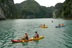 Du khách bơi thuyền Kayak trên Vịnh Hạ Long. (Ảnh: Tiến Dũng/TTXVN) 