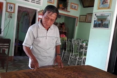 Ông Châu giới thiệu bản sắc phong có niên đại gần nhất của vua Khải Định. (Ảnh: Sỹ Thắng/TTXVN)