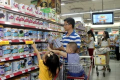 Người tiêu dùng chọn mua sản phẩm sữa tại siêu thị. (Ảnh: Thanh Vũ/TTXVN)