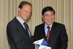 Đại sứ Bruno Angelet tặng sách trắng cho Chủ tịch UBND TP Hồ Chí Minh Nguyễn Thành Phong. (Ảnh: Thanh Vũ/TTXVN)