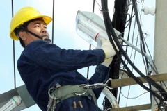 Công nhân ngành điện TP Hồ Chí Minh thực hiện công trình nguồn sáng an toàn, văn minh và tiết kiệm. (Ảnh: Thanh Vũ/TTXVN)