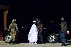 Tổng thống mãn nhiệm Gambia Yahya Jammeh (giữa) lên máy bay tại sân bay Banjul ngày 21/1. (Ảnh: AFP/TTXVN)