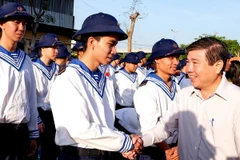Chủ tịch UBND Thành phố Hồ Chí Minh Nguyễn Thành Phong chúc mừng và động viên các thanh niên trúng tuyển nghĩa vụ quân sự tại điểm giao quân Quận 9, TP.HCM. (Ảnh: Thế Anh/TTXVN)