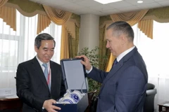 Phó Thủ tướng Liên bang Nga Yury Trutnev tặng quà Trưởng Ban Kinh tế Trung ương Nguyễn Văn Bình. (Ảnh: Quang Vinh/TTXVN)