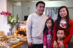 Gia đình anh Sơn bên mâm cơm tất niên. (Ảnh: Gia Quân/Vietnam+)