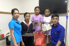 Đại diện Trường Phổ thông Dân tộc bán trú Tiểu học và Trung học Cơ sở La Pán Tẩn thăm hỏi, động viên em Lù Thị L. tại bệnh viện. (Ảnh: TTXVN phát)