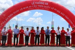  Lãnh đạo Bộ Giao thông vận tải và UBND tỉnh Long An cắt băng khánh thành thông xe cầu Tân An. Ảnh: Thanh Bình- TTXVN