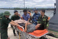 Lực lượng Bộ đội Biên phòng Quảng Trị đưa thuyền viên bị bệnh vào bờ để điều trị. (Ảnh: TTXVN phát)