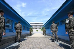 Binh sỹ Hàn Quốc (phía trước) và binh sỹ Triều Tiên (phía sau) gác tại đường giới tuyến phi quân sự giữa hai miền Triều Tiên ở Panmunjom ngày 26/4/2018. (Ảnh: AFP/ TTXVN)