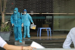 Cơ quan chức năng thực hiện các biện pháp y tế tại một tòa nhà của Bộ Công Thương do liên quan đến ca F0 đến làm việc. (Ảnh: Phan Lâm/Vietnam+)