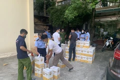 Lực lượng Quản lý thị trường và Công an quận Tây Hồ kiểm tra cơ sở kinh doanh rượu trên địa bàn phường Yên Phụ. (Ảnh: PV/Vietnam+)