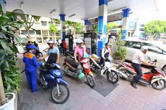 Nhân viên Petrolimex đang bán xăng cho khách hàng. (Ảnh: Đức Duy/Vietnam+)