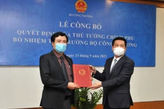 Ông Nguyễn Sinh Nhật Tân (bên trái) nhận quyết định Thứ trưởng Bộ Công Thương. (Ảnh: PV/Vietnam+)