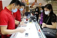 Khách hàng giao dịch vàng miếng. (Ảnh: TTXVN)