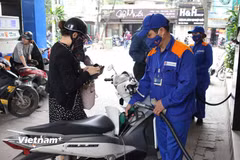 Nhân viên Petrolimex bán xăng cho khách hàng. (Ảnh: Đức Duy/Vietnam+)