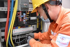 Nhân viên EVNHANOI kiểm tra tình trạng vận hành của thiết bị điện. (Ảnh: PV/Vietnam+)