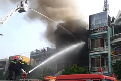 Lực lượng phòng cháy chữa cháy nỗ lực dập lửa. (Ảnh: Trần Lê Lâm/TTXVN)