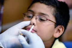 Xịt vắcxin phòng cúm H1N1 cho học sinh tiểu học. (Ảnh: AFP/TTXVN)