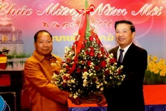 Thứ trưởng Bộ An Ninh Kào Somkeo Silavong (bên trái) tặng hoa chúc mừng Xuân Giáp Ngọ 2014. (Ảnh: Hoàng Chương/Vietnam+)