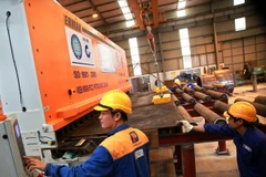 Công ty Cổ phần Xây lắp 1-Petrolimex vận hành dây chuyền máy cắt sắt. (Ảnh: Trọng Đạt/TTXVN).
