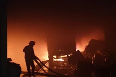 Lực lượng cứu hỏa đang khống chế ngọn lửa. (Ảnh: TTXVN phát)