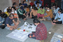 Các đối tượng đánh bạc bị bắt quả tang tại hiện trường. (Ảnh: TTXVN phát)