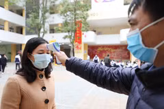 Trường THPT Trần Nhân Tông, quận Hai Bà Trưng (Hà Nội) thực hiện đo thân nhiệt, sát khuẩn tay cho cán bộ, giáo viên và học sinh mỗi khi ra, vào trường (ảnh chụp sáng 29/1). (Ảnh: Thanh Tùng/TTXVN)