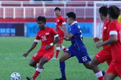 U21 Singapore (áo đỏ) đã có màn ngược dòng rất ấn tượng trong hiệp hai cuộc đối đầu với U21 Thái Lan tối qua. (Ảnh: Minh Chiến/Vietnam+)