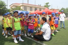 Ông Hoàng Hà - Giám đốc Marketing toàn quốc Yamaha Motor Việt Nam (áo trắng) trò chuyện cùng các cầu thủ nhí lứa tuổi U6 trước giờ thi tuyển. (Ảnh: Ban tổ chức)