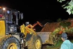 Rạng sáng 31/7, lực lượng chức năng vẫn làm việc để giải tỏa hiện trường vụ sạt lở và tìm kiếm nạn nhân mất tích. (Ảnh: Nguyễn Dũng/ TTXVN)