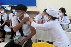 Nhân viên y tế tiêm vaccine phòng COVID-19 (mũi 3) cho học sinh tại thành phố Tuy Hòa, tỉnh Phú Yên. (Ảnh: Xuân Triệu/TTXVN)
