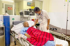 Bác sỹ Bệnh viện Quân y 175, Thành phố Hồ Chí Minh thăm khám cho các nạn nhân ngộ độc rượu sáng 15/7. (Ảnh: TTXVN phát)