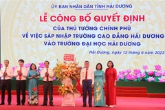 Ủy viên TW Đảng, Bộ trưởng Bộ Giáo dục và Đào tạo Nguyễn Kim Sơn (thứ 4 từ trái sang) tặng hoa chúc mừng Ban giám hiệu Trường Đại học Hải Dương. (Ảnh: Mạnh Tú/TTXVN)