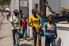 Người dân rời bỏ nhà cửa sau cuộc tấn công của bang nhóm tội phạm tại Port-au-Prince, Haiti. (Ảnh: AFP/TTXVN)