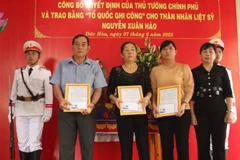 Phó Chủ tịch UBND tỉnh Long An-Huỳnh Văn Sơn trao bằng Tổ quốc ghi công cho thân nhân liệt sỹ Nguyễn Xuân Hào. (Ảnh: TTXVN phát)