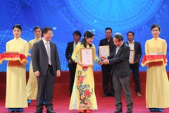 Phó Tổng Giám đốc TTXVN Nguyễn Tuấn Hùng và Phó Tổng Biên tập báo Nhân Dân Đinh Như Hoan trao giải cho tác giả Phạm Mai, Báo điện tử VietnamPlus (TTXVN). (Ảnh: Thanh Tùng/TTXVN)