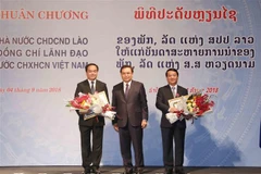 Đồng chí Saysomphone Phomvihane, Ủy viên Bộ Chính trị, Chủ tịch Ủy ban Trung ương Mặt trận Lào Xây dựng đất nước trao Huân chương Tự do cho các đồng chí lãnh đạo Đảng, Nhà nước Việt Nam. (Ảnh: Phương Hoa/TTXVN)