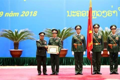 Thượng tướng Chansamone Chanyalath trao Huân chương Tự do Itxala của Nhà nước Lào cho Thượng tướng Phan Văn Giang. (Ảnh: Dương Giang/TTXVN)