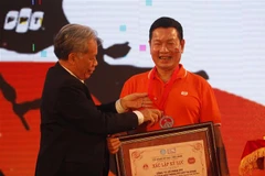 Ông Trương Gia Bình, Chủ tịch Hội đồng quản trị, Tổng Giám đốc Tập đoàn FPT nhận bằng chứng nhận kỷ lục Việt Nam. (Ảnh: Thế Anh/TTXVN)