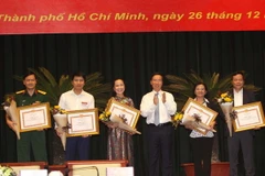 Đồng chí Võ Văn Thưởng, Ủy viên Bộ Chính trị, Bí thư Trung ương Đảng, Trưởng Ban Tuyên giáo Trung ương trao bằng khen cho các tập thể đạt thành tích trong năm 2017. (Ảnh: Thanh Vũ/TTXVN)